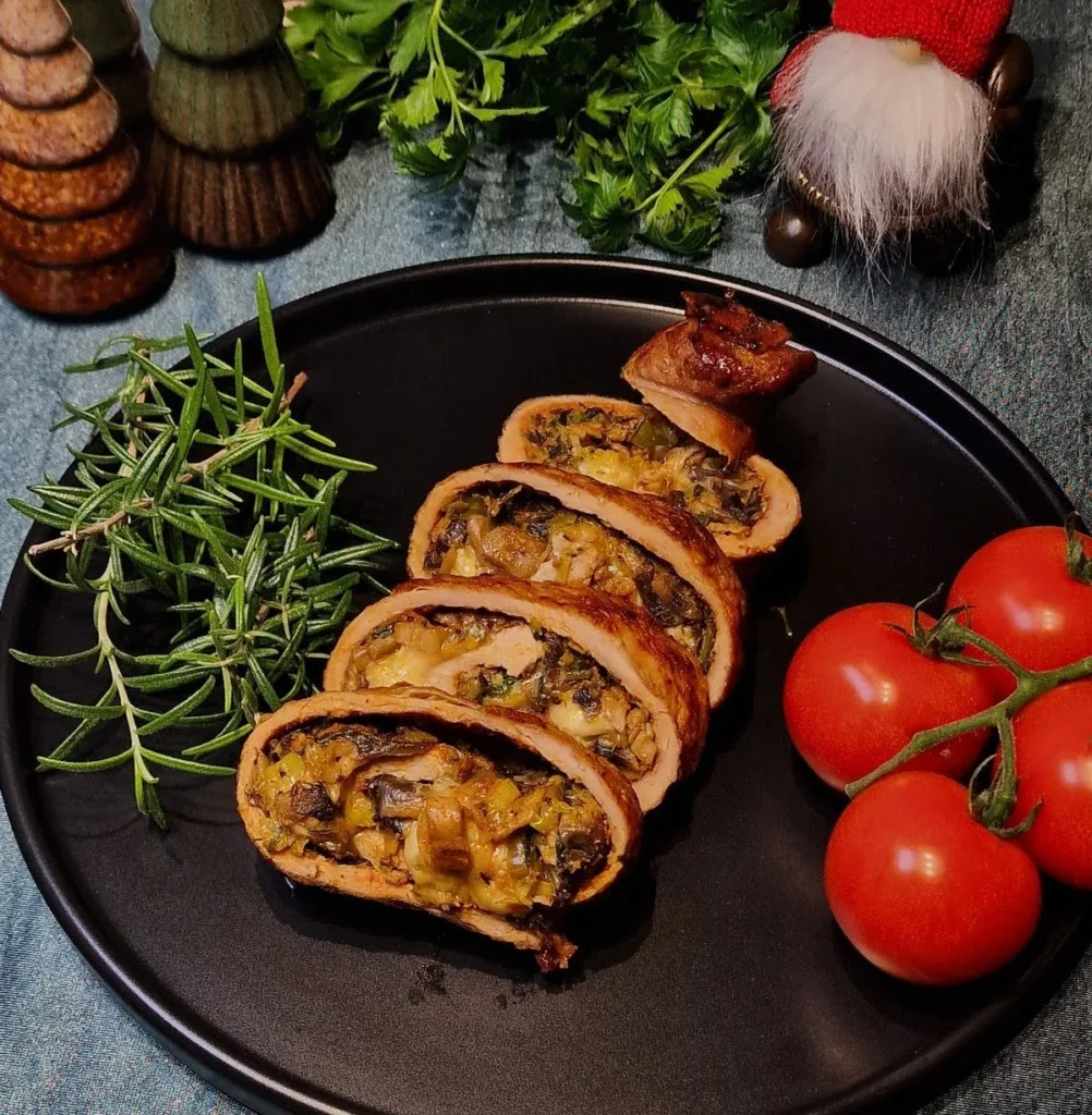 1.	Polędwiczka wieprzowa faszerowana pieczarkami, porem i serem żółtym pokrojona w plastry i podana na talerzu.